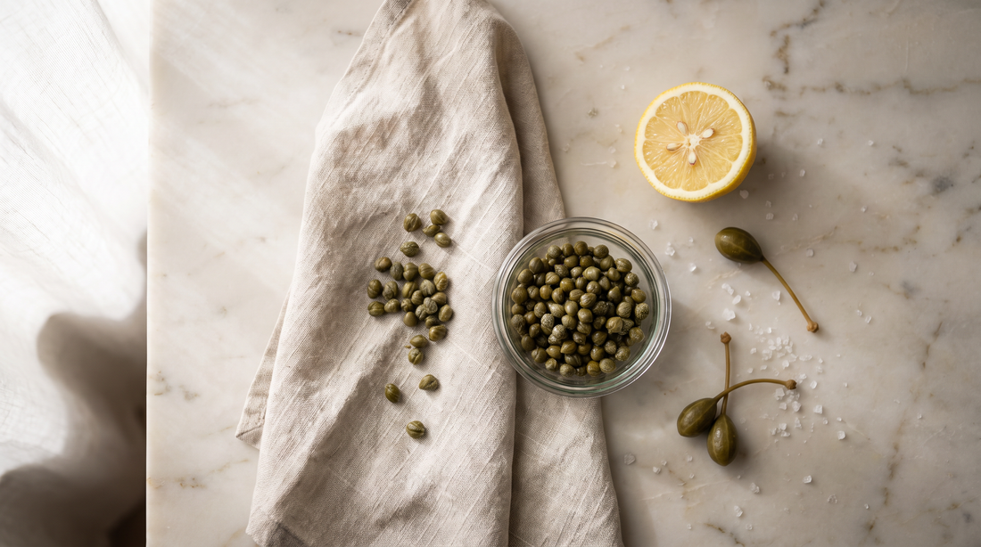 Drained capers blotted on a linen towel, the first step in how to fry capers until crisp