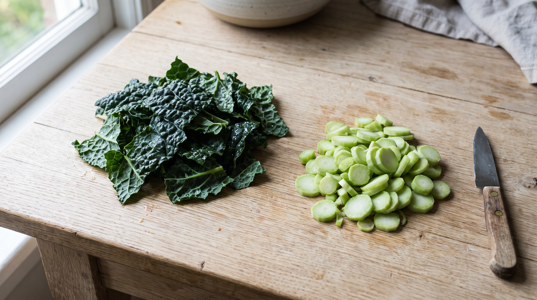 Kale stems and leaves separated into two piles on a wooden counter before cooking