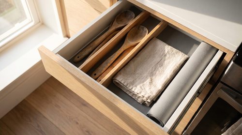 Narrow kitchen drawer with slim dividers, the setup used for pot lid storage in a small kitchen